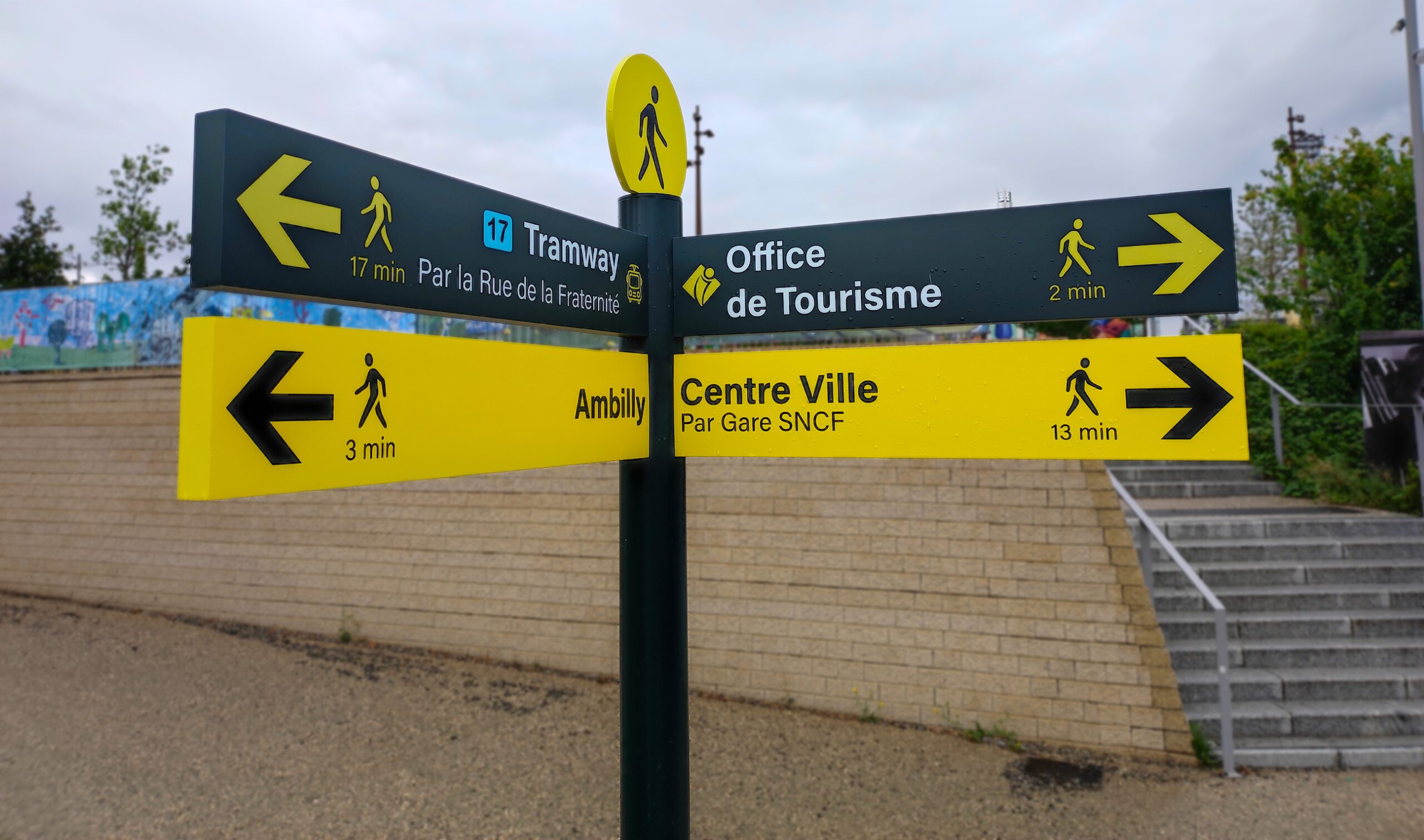 Poteau de signalétique piétonne indiquant Tramway, Office de Tourisme, Ambilly et Centre Ville avec temps de marche