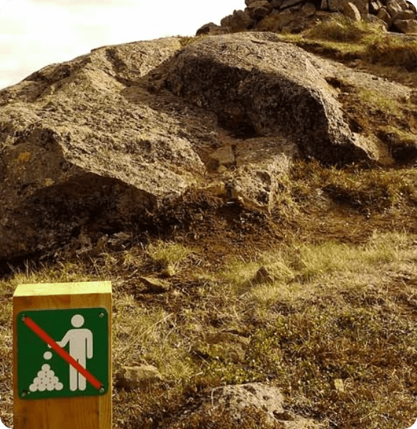 Poteau en bois avec un pictogramme barré représentant une personne déposant