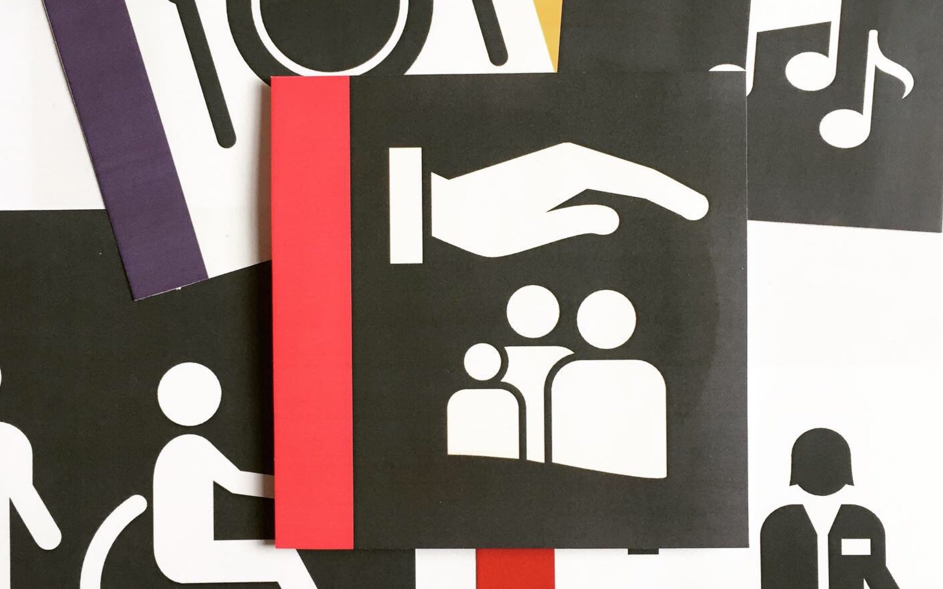 Panneaux graphiques noir et blanc avec pictogrammes main protectrice, famille, fauteuil roulant et notes de musique