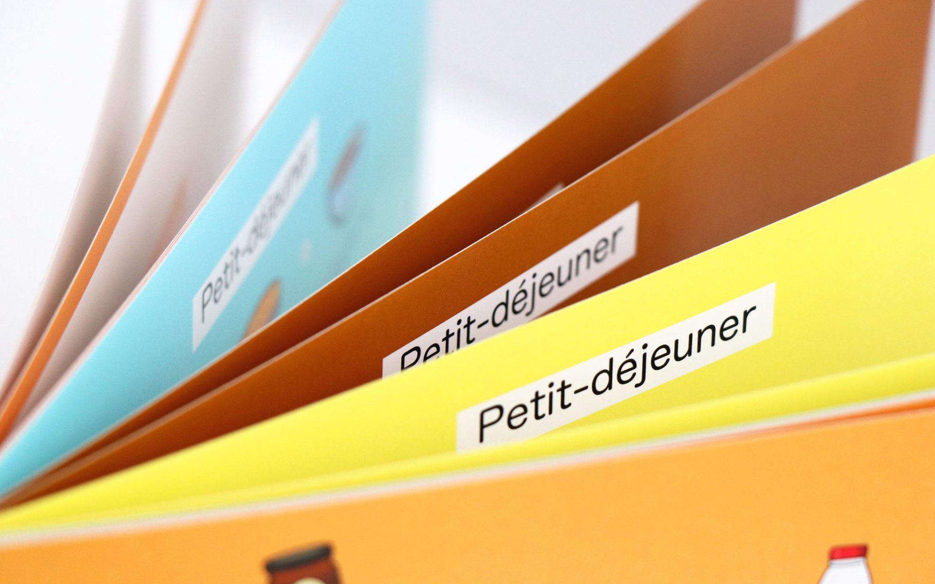 Intercalaires colorés avec étiquettes « Petit-déjeuner », rangés en éventail dans un classeur ou un support